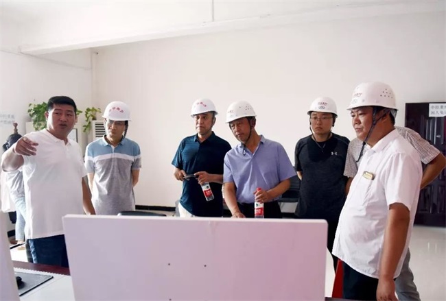團(tuán)隊考察生產(chǎn)線上的中控室